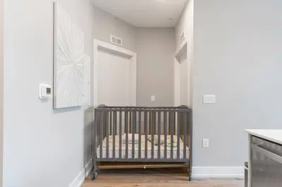 a crib in a room with a white wall at Sleeps 6 - Pier Views - Near Fishtown and Old City in Philadelphia
