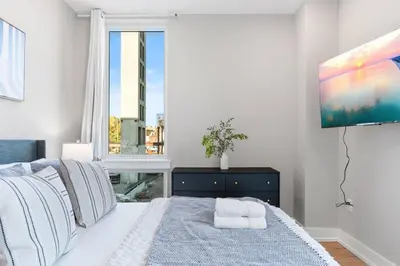 a bedroom with a bed and a large window at Sleeps 6 - Pier Views - Near Fishtown and Old City in Philadelphia