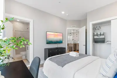 a white bedroom with a bed and a bathroom at Sleeps 6 - Pier Views - Near Fishtown and Old City in Philadelphia