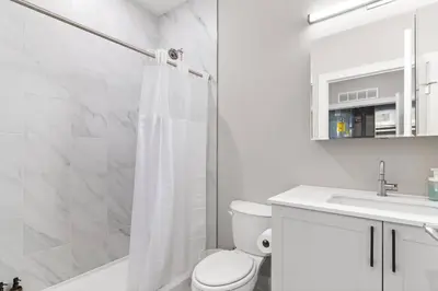 a bathroom with a shower and a toilet and a sink at Charming Studio with Breathtaking Pier and Bridge Views in Philadelphia