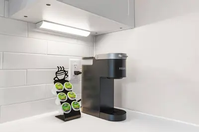 a coffee machine in a room with white walls at Charming Studio with Breathtaking Pier and Bridge Views in Philadelphia