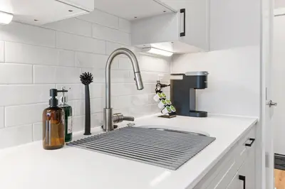 a kitchen sink with a metal grate in it at Charming Studio with Breathtaking Pier and Bridge Views in Philadelphia