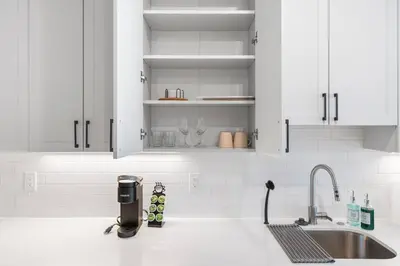 a kitchen with white cabinets and a sink at Modern 1-BD - Pier Views - Near Old City in Philadelphia