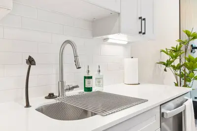 a kitchen counter with a sink with two bottles on it at Modern 1-BD - Pier Views - Near Old City in Philadelphia