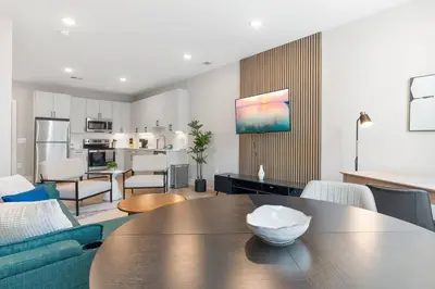 a living room with a table and a kitchen at Modern 1-BD - Pier Views - Near Old City in Philadelphia