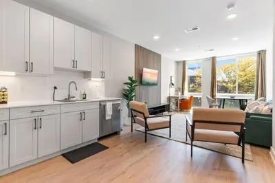 a kitchen with white cabinets and a living room at 1BD - Sleeps 4 - Harbor Views - Near Fish Town- in Philadelphia