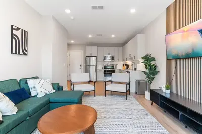 a living room with a green couch and a table at 1BD - Sleeps 4 - Harbor Views - Near Fish Town- in Philadelphia
