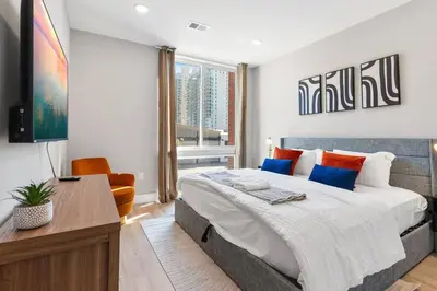 a bedroom with a large bed and a desk in it at King Bed - Stunning Pier Views - Near Fishtown in Philadelphia