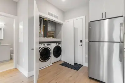 a kitchen with a refrigerator and a washer and dryer at King Bed - Stunning Pier Views - Near Fishtown in Philadelphia