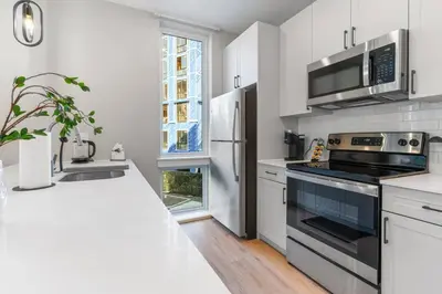 a white kitchen with a stove and a refrigerator at Amazing City Views - Sleeps 6 - Near Fishtown in Philadelphia
