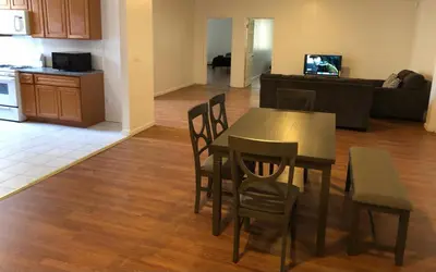 a kitchen and a dining room with a table and chairs at Large apartment, sleeps up to 10 people comfortably, direct NYC Manhattan train only 5 minute walk away, MetLife Stadium FIFA World Cup 25 minutes away in Elizabeth