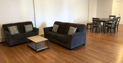 a living room with two couches and a table at Large apartment, sleeps up to 10 people comfortably, direct NYC Manhattan train only 5 minute walk away, MetLife Stadium FIFA World Cup 25 minutes away in Elizabeth