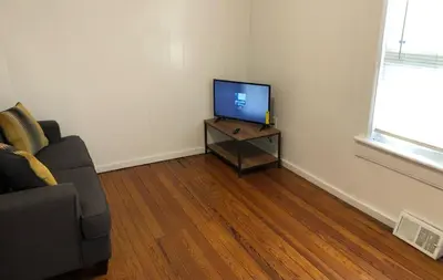 a living room with a couch and a television on a table at Private and cozy house with one bedroom and one bathroom, MetLife Stadium FIFA World Cup 35 minutes away in Perth Amboy