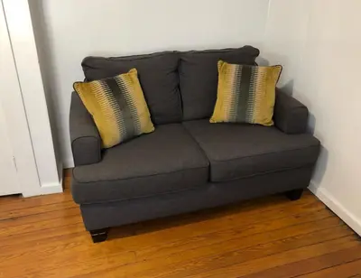 a gray couch with two yellow pillows on it at Private and cozy house with one bedroom and one bathroom, MetLife Stadium FIFA World Cup 35 minutes away in Perth Amboy