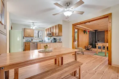 a kitchen with a wooden table and a ceiling fan at Ski, Unwind, Play Near Big Boulder, Game Room in Blakeslee