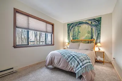 a bedroom with a bed with a painting on the wall at Ski, Unwind, Play Near Big Boulder, Game Room in Blakeslee