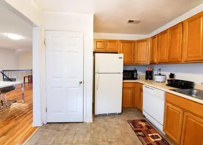 a kitchen with a white refrigerator and wooden cabinets at Golf view family friendly 3 bed room Bridgewater apt close to Bridgewater Mall in Bridgewater