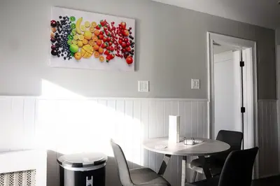 a dining room with a table and a painting of fruits at Modern 2BR, Easy access to NYC in Jersey City
