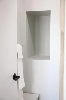 a white bathroom with a toilet and a mirror at Modern 2BR, Easy access to NYC in Jersey City