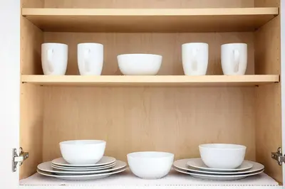 a shelf with white bowls and plates in a cabinet at Modern 2BR, Easy access to NYC in Jersey City