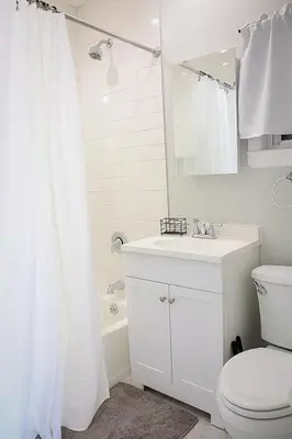 a white bathroom with a toilet and a sink at Modern 2BR, Easy access to NYC in Jersey City