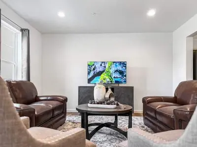 a living room with two leather chairs and a table at Luxurorious Townhome In Reading in Mount Penn