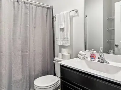 a white bathroom with a toilet and a sink at Luxurorious Townhome In Reading in Mount Penn