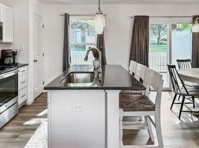 a kitchen with a sink and a table with chairs at Luxurorious Townhome In Reading in Mount Penn