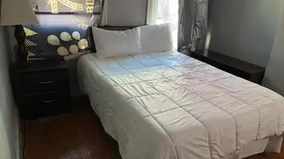 a bedroom with a bed with a white comforter and a window at 2218 N Colorado Master Queen Room in Dogwood Acres