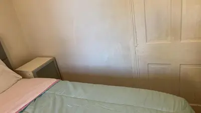 a small room with a bed and a door at 2218 N Colorado Master Queen Room in Dogwood Acres