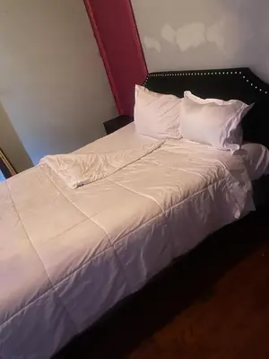 a bed with white sheets and pillows at 2218 N Colorado Master Queen Room in Dogwood Acres