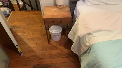 a small table with a trash can next to a bed at 2218 N Colorado Master Queen Room in Dogwood Acres