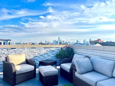 a patio with two chairs and a couch on a roof at Charles Peak Condo - JC Heights in Jersey City