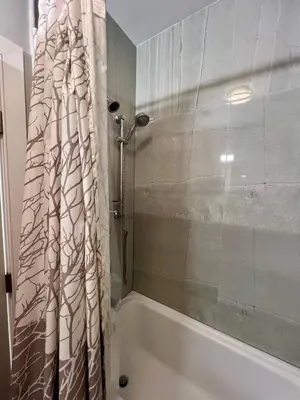a bathroom with a shower curtain and a tub at Charles Peak Condo - JC Heights in Jersey City