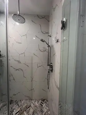 a shower with a glass door in a bathroom at Charles Peak Condo - JC Heights in Jersey City