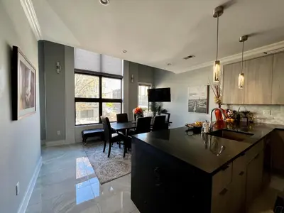 a kitchen and living room with a table and chairs at Charles Peak Condo - JC Heights in Jersey City