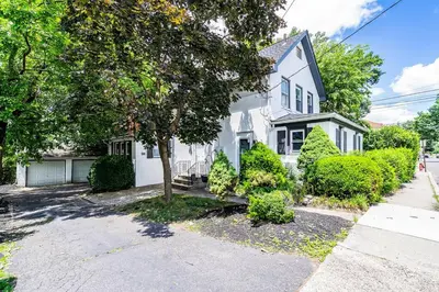 a white house with a tree in front of it at Two-Bedroom Home 25 min to NYC free parking-UNIT-2 in Teaneck
