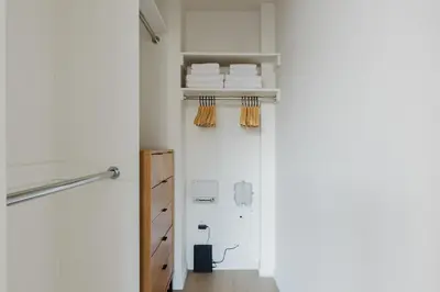 a room with white walls and a hallway with wooden shelves at Blueground Upper West Side nr parks wd NYC-1678 in New York