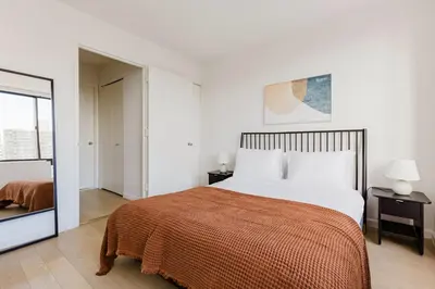 a bedroom with a large bed with a orange blanket at Blueground Upper West Side nr parks wd NYC-1678 in New York