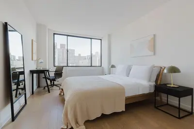 a bedroom with a large bed and a table and chairs at Blueground Upper West Side nr parks wd NYC-1678 in New York