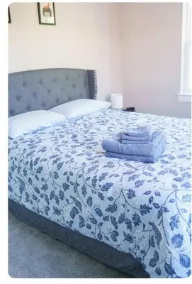 a bed with a blue and white comforter with towels on it at Hidden Gem in Norristown