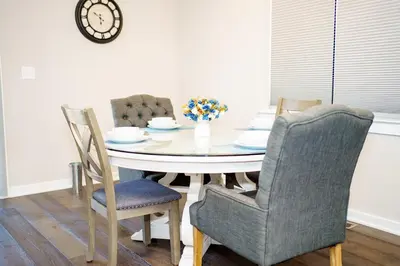 a dining room table with chairs and a clock on the wall at Hidden Gem in Norristown
