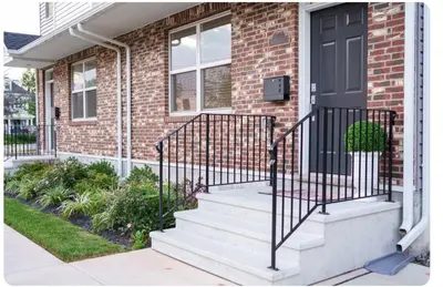 a brick house with stairs and a black door at Hidden Gem in Norristown