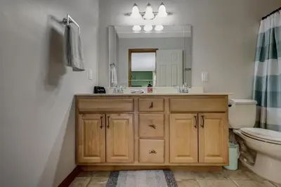 a bathroom with a sink and a toilet and a mirror at Locust Lake Livin Hot Tubfire Pitskiingpets in Pocono Lake