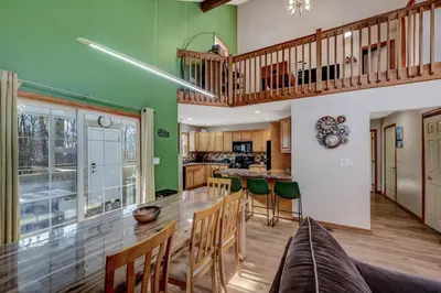 a large kitchen with a wooden table and chairs at Locust Lake Livin Hot Tubfire Pitskiingpets in Pocono Lake