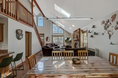 a dining room and living room with a table and chairs at Locust Lake Livin Hot Tubfire Pitskiingpets in Pocono Lake