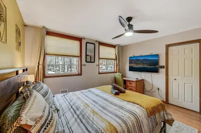 a bedroom with a bed and a ceiling fan at Locust Lake Livin Hot Tubfire Pitskiingpets in Pocono Lake