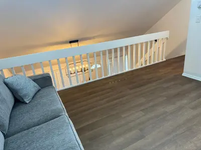 a living room with a couch and a staircase at poconos mountain luxury cozy vacational house in the heart of Poconos in Tobyhanna
