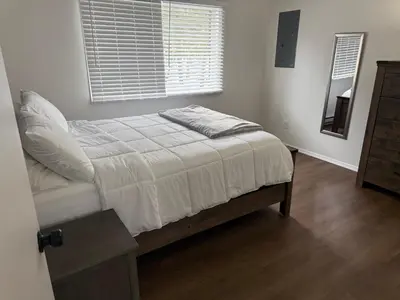 a bed in a white bedroom with a window at poconos mountain luxury cozy vacational house in the heart of Poconos in Tobyhanna