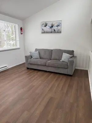 a living room with a couch and wooden floors at poconos mountain luxury cozy vacational house in the heart of Poconos in Tobyhanna